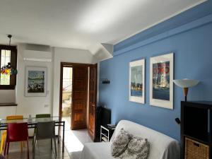 una sala de estar con una pared azul en Loft - Lago di Como Apt, en Menaggio