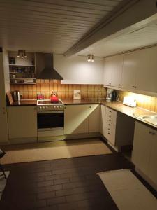cocina grande con armarios y electrodomésticos blancos en Rummeligt byhus i Allinge med værelse i stueplan og havkig, en Allinge