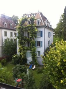 ein großes weißes Gebäude mit einem Hof davor in der Unterkunft Wunderschöne Gartenwohnung in Zürich in Zürich