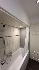ein Badezimmer mit einer Badewanne mit Duschvorhang in der Unterkunft Wunderschöne Gartenwohnung in Zürich in Zürich