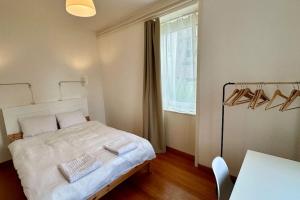 Schlafzimmer mit einem Bett, einem Tisch und einem Fenster in der Unterkunft Wunderschöne Gartenwohnung in Zürich in Zürich