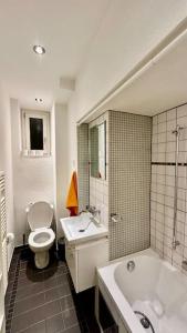 La salle de bains est pourvue d'une baignoire, de toilettes et d'un lavabo. dans l'établissement Wunderschöne Gartenwohnung in Zürich, à Zurich