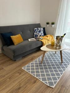 a living room with a couch and a table at Apartament White glove Nowe Zatorze in Olsztyn
