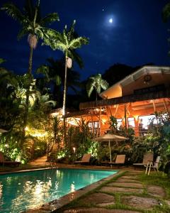 a resort with a swimming pool at night at Øko Villa in Juquei