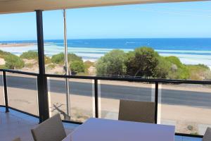 Cette chambre comprend une table et des chaises et offre une vue sur la plage. dans l'établissement The Lighthouse - Beachfront Accommodation, à Port Hughes