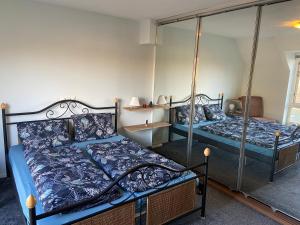 a bedroom with two beds and a mirror at Appartement Twins in Wijk aan Zee