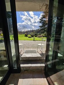 una puerta abierta a un patio con 2 sillas blancas en La casetta di Gianni, en Borgo Ticino