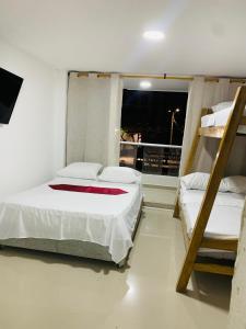 a bedroom with two bunk beds and a window at Hotel Belmar piso 2 in Cartagena de Indias