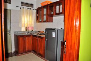 a kitchen with wooden cabinets and a refrigerator at Kisoro Homely Suites in Kisoro