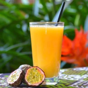 a glass of orange juice next to a cut fig at Kisoro Homely Suites in Kisoro