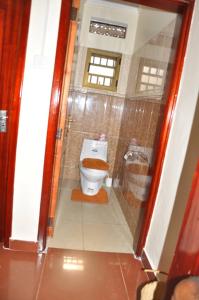 a bathroom with a toilet with a brown seat at Kisoro Homely Suites in Kisoro