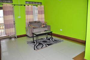 a living room with a couch and a table on a rug at Kisoro Homely Suites in Kisoro