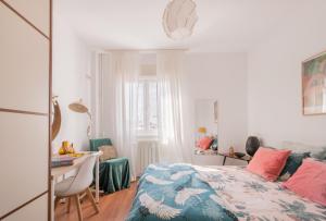 a bedroom with a bed and a desk and a table and chair at Sunlit cosy haven a spacious treasure to be discovered in Madrid
