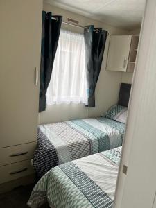 two beds in a small room with a window at Ailsa View in Lendalfoot