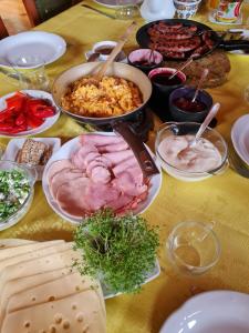 Pensjonacik Ogrody في بياشخنو: طاولة بها العديد من الأطباق المختلفة من الطعام