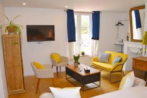 un soggiorno con tavolo e sedie gialle di Manoir Drissia - Tours Centre, France a Saint-Avertin