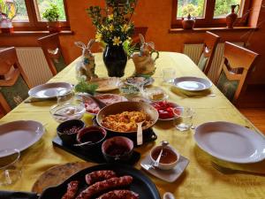 stół z talerzami i miskami z jedzeniem w obiekcie Pensjonacik Ogrody w mieście Pierzchno