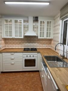 een keuken met witte kasten en een wastafel bij Sitges Center Penthouse in Sitges