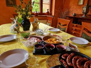 een tafel met borden en kommen met voedsel bij Pensjonacik Ogrody in Pierzchno