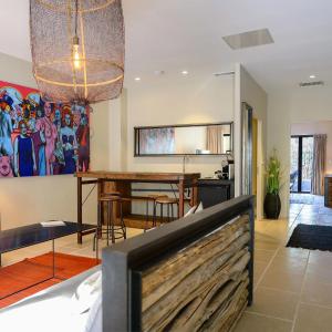 a living room with a table and a dining room at Domaine Tarbouriech, Hôtel & Spa in Marseillan