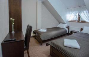 MielnoにあるZajazd Drogorad Restauracja i Noclegiのベッド2台とデスクが備わるホテルルームです。