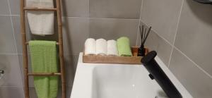 a bathroom with a towel rack and towels on a tub at Alojamento local Os Maias in Mirandela