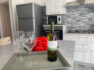eine Flasche Wein auf einem Tisch mit zwei Weingläsern in der Unterkunft Appartamento di Mara in Tertenìa