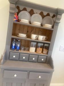 a hutch filled with dishes and bottles of water at Luxury Country Escape in Ennis