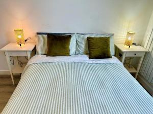 ein Schlafzimmer mit einem Bett mit zwei Lampen an Tischen in der Unterkunft Large En-Suite Studio with private bath and kitchen In Canary Wharf 4 in London