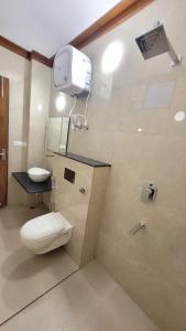 La salle de bains est pourvue de toilettes et d'une lumière sur le mur. dans l'établissement Gupta Vilas - A Boutique Homestay, à Agra