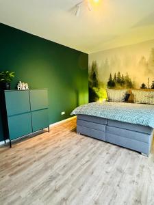 um quarto com uma cama e uma parede verde em Hauptstadt Mitte em Waigolshausen