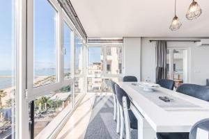 a dining room with a white table and views of the ocean at Seaview Luxury Suite by PS in Golem