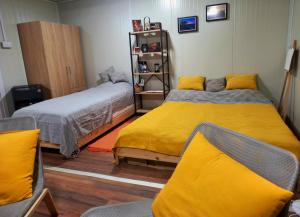 two beds in a room with yellow sheets at Od svitanja do sumraka in Golubac