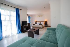 un salon avec un canapé vert et une chambre avec un lit dans l'établissement Ladonia Hotels Zemda Gümüşlük, à Gümüşlük