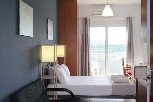キサモスにあるVillage Drapanias Apartmentsのベッドと窓が備わるホテルルーム