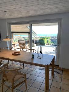 una sala da pranzo con tavolo e sedie in legno di Luxury house with breathtaking sea view of Mols a Rønde