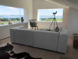 a living room with a couch and a window at Luxury house with breathtaking sea view of Mols in Rønde