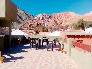 a patio with a table and chairs and mountains at Ipay Alojamiento Familiar in Purmamarca