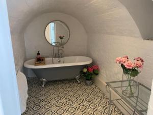 a bathroom with a tub and a mirror and flowers at Seaside Holiday Home, Ramsgate, Latimer House in Ramsgate