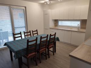a kitchen and dining room with a table and chairs at BÖJTÖS apartmány NESVADY in Nesvady