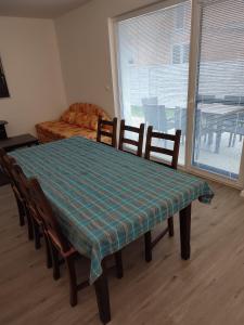 a dining room table and chairs with a table and a couch at BÖJTÖS apartmány NESVADY in Nesvady