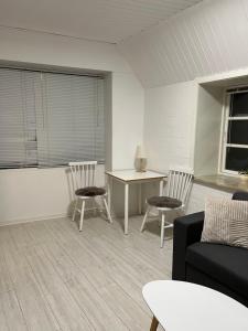 uma sala de estar com um sofá, cadeiras e uma mesa em Apartment with Wifi, close to city center, Beach and forrest em Aabenraa