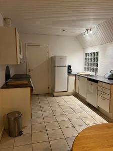 cocina con nevera y suelo de baldosa. en Apartment with Wifi, close to city center, Beach and forrest en Aabenraa