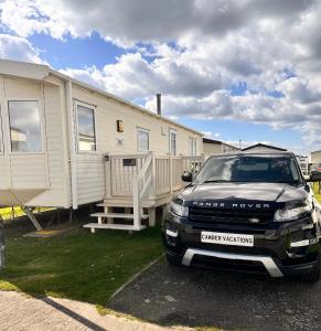 a car parked in front of a mobile home at Camber Vacations in Camber