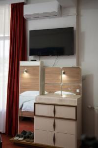 a bedroom with a bed with a tv on the wall at Soba Kašmir in Bugojno