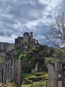 a castle on top of a hill with a fence at Au pied du Frêne in Saint-Privat +2 photos