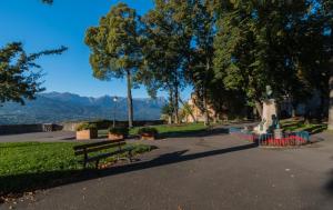 a park with a bench and a statue and trees at Métropole in Embrun