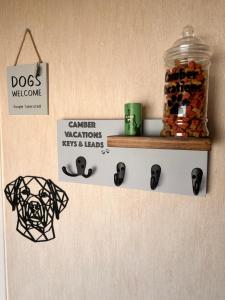 a wall with a shelf with a jar of dog medications at Camber Vacations in Camber