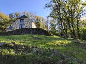 een stenen huis bovenop een grasheuvel bij Les Termes in Saint-Chély-dʼAubrac