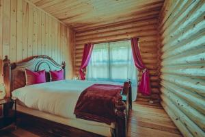 a bedroom with a bed in a log cabin at Bee Private Hot Tub Sauna Ski, Snowshoes in Mille-Isles +71 photos